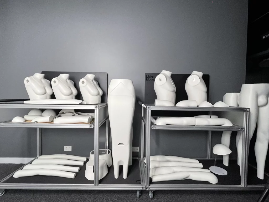 Modular Ghost Mannequin parts neatly organized on steel racks at a studio.